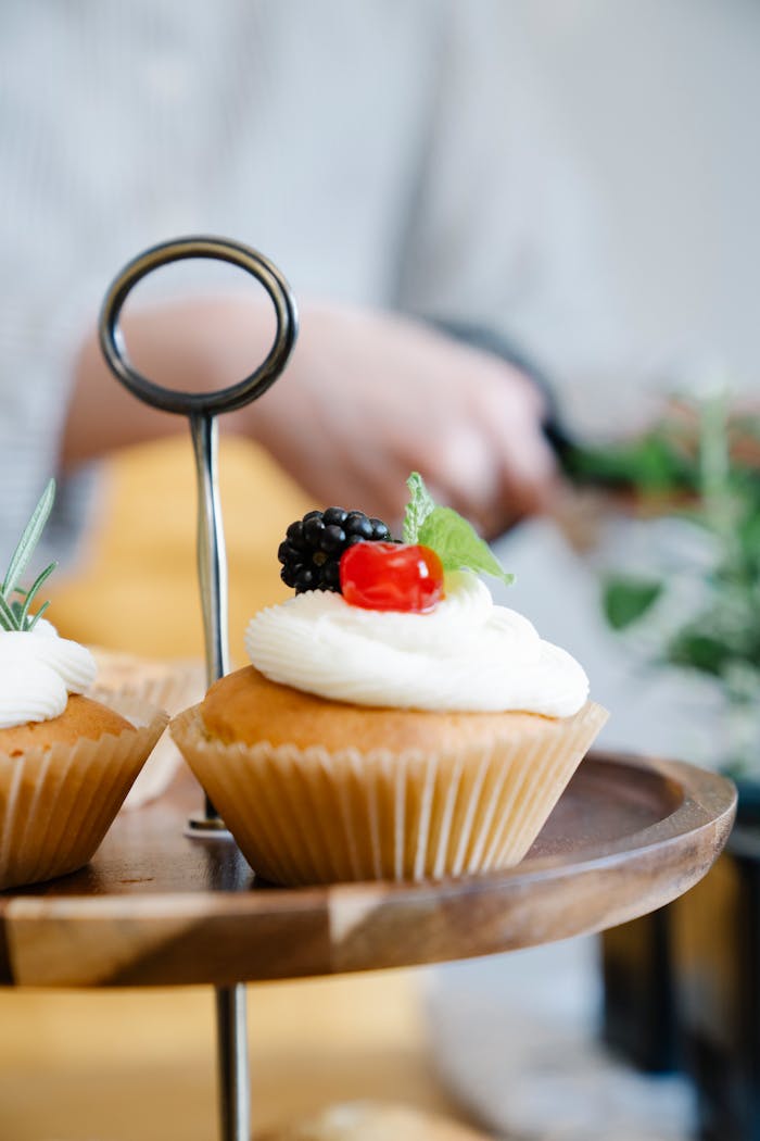 Delicious cupcakes topped with fresh berries and cream, perfect for desserts and celebrations.